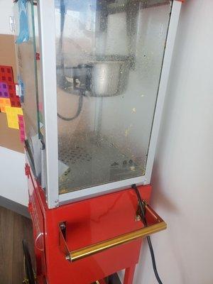 Popcorn machine in waiting area at 10a. Looks like it hasn't been cleaned in days.