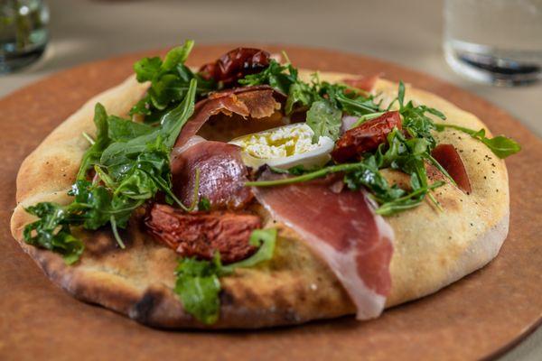 Prosciutto and Burrata: Olive Oil Brushed Flat Bread, Burrata, Prosciutto, Oven Dried Tomato, Arugula, Balsamic Syrup, EVOO