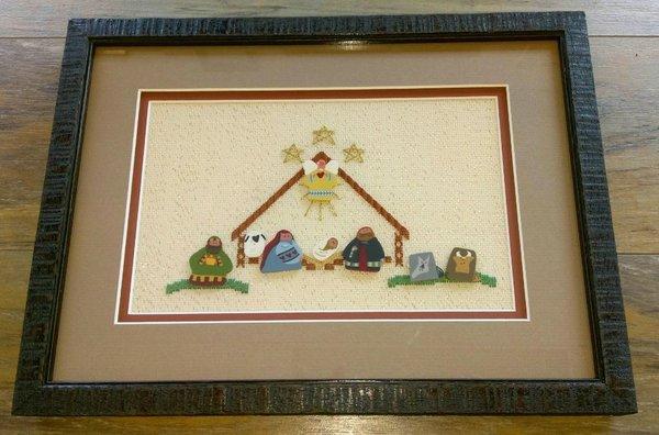 Framed, matted, and stretched needlework with spacers between mats.