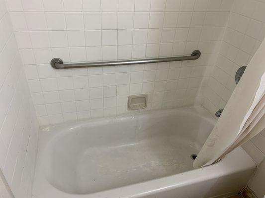 Filthy tub with no soaps or shampoo.