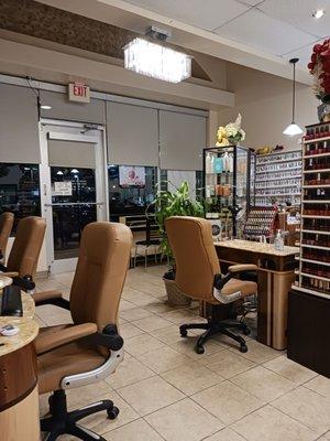 Several manicure booths, nail color selection, gel and powder nail colors, well light business with elegant light fixtures.