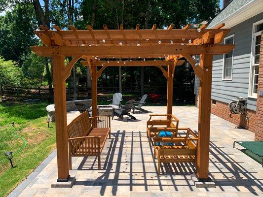 This view shows the pergola build as well as the fire pit and seating wall area in the back.