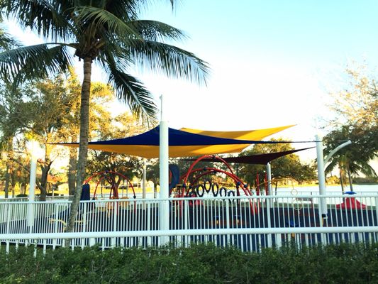 This is a beautiful tri colored sail canopies over a playground