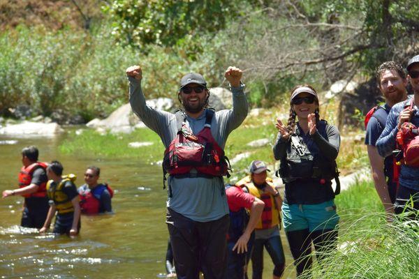 Guide staff cheering on the participants as they enjoy the river slide!