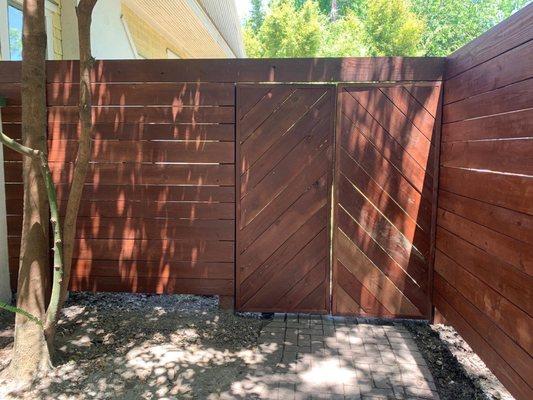 Beautiful and stout fence we built! 6x6 Post with 160lbs of concrete per. 2x6 & 2x8 horizontal boards and some cool chevron doors!