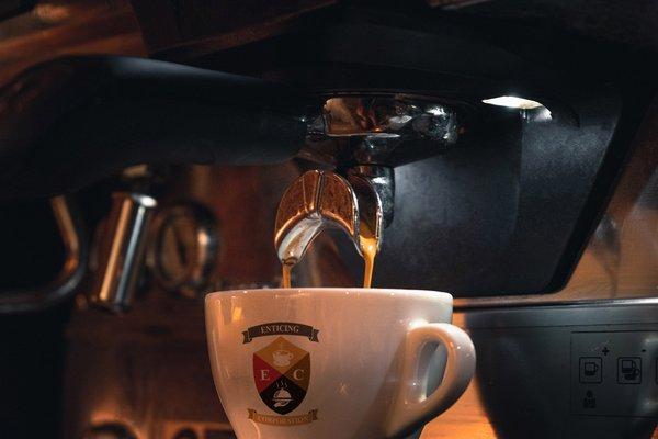 delicious Italian espresso pouring into Enticing Coffee mug for latte