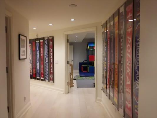 Acrylic float mounted display of soccer (football) scarves in basement sports area.