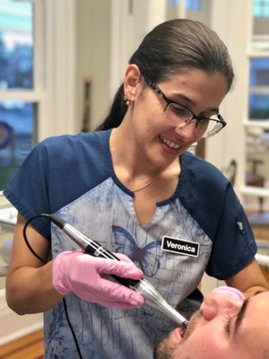 Veronica taking photos of the patient's teeth using an intra-oral camera.  Pictures are taken of all our patients at their first visit