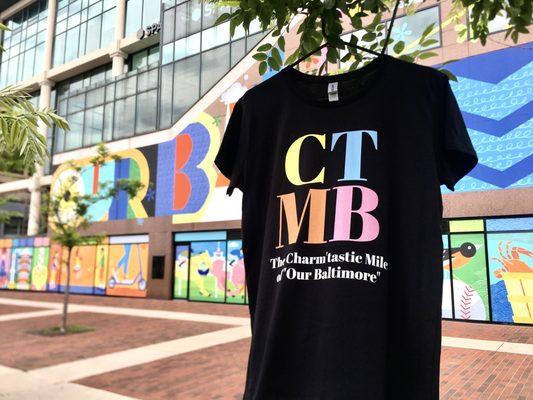 The new (CTMB) brand souvenir T-Shirt in front of the 'Our Baltimore' Mural.