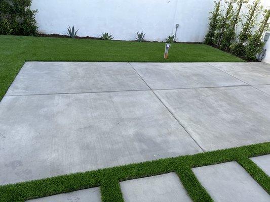 Concrete pad with artificial turf installation.