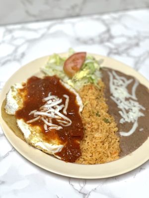 Huevos rancheros . 2 over easy eggs topped with ranchero sauce served with rice and beans.