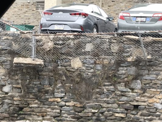 Damaged fencing that keeps people from falling to their death or being seriously injured into the parking lot below