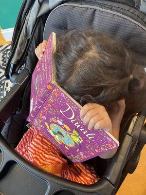 My daughter reading the Diwali book we got her from here