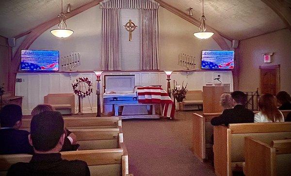 The space for the viewing had nice seats with optional padded kneelers. The dual video display showed the name of the veteran.