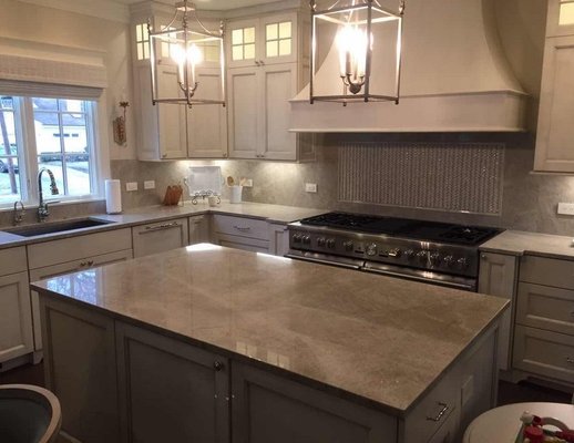 Taj Mahal Quartzite Countertops and Full Backsplash on White Cabinet in Luxury Home