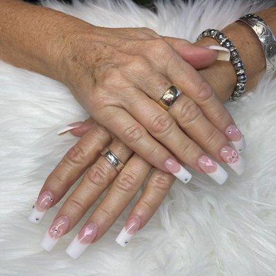 Acrylic pink and white french with designs of bows,hearts, and crystals. Cindy painted all by hand.