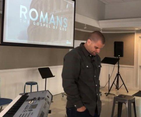 Pastor Chris Lujan praying before teaching in Romans 2023