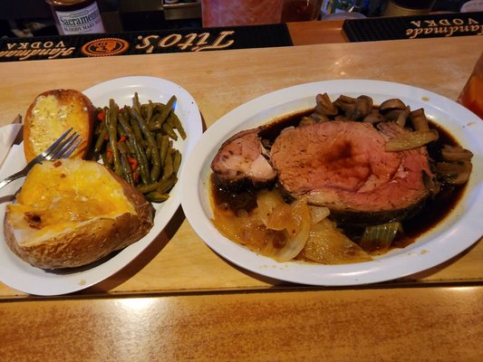 Queen cut prime rib with green beans, baked potato, and garlic bread