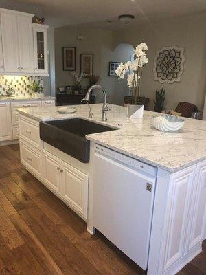 Large island with farmhouse sink and quartz countertop.