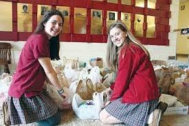 Community service is one of the required courses for graduation from Seton High.  Here, two students assist with a food drive.