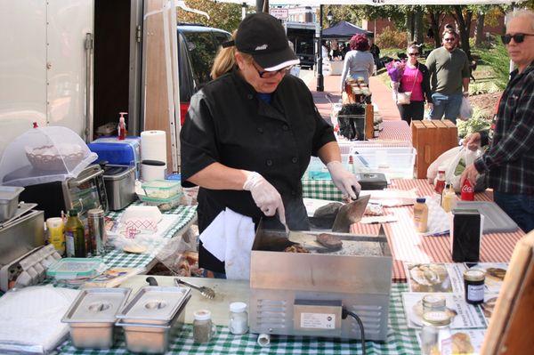 Tina on the grill making one of her famous Alpen burgers for a customer.