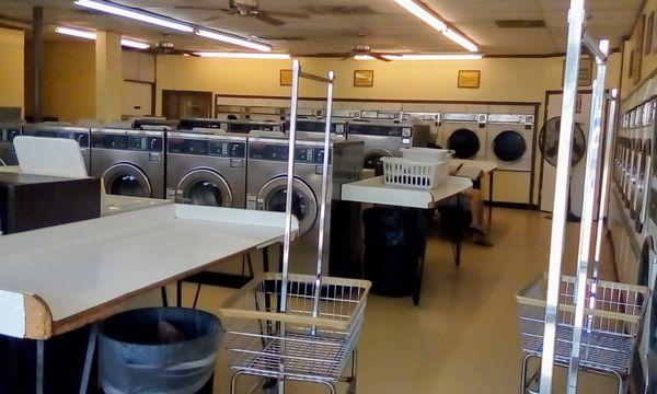 Banks of washing machines, different sizes, clean and well-lit, fans to stay cool.