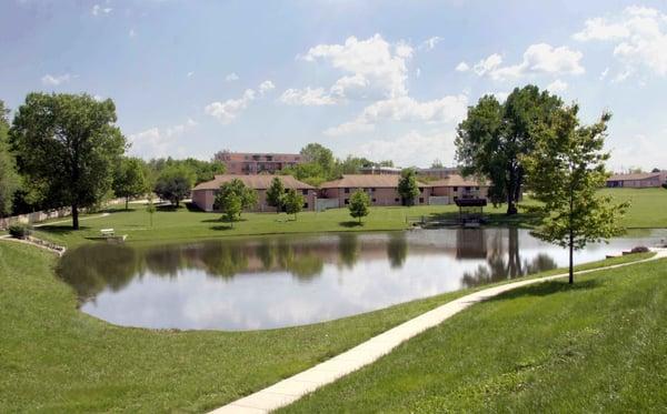 The campus features a pond and walking path for residents to enjoy.