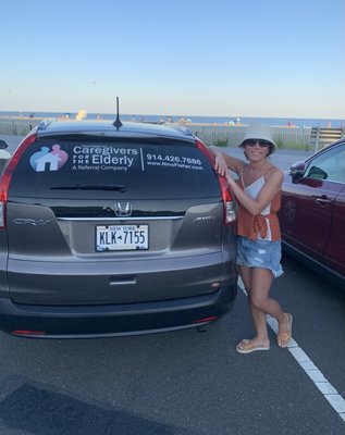 Caregiver Nana standing by our company car.