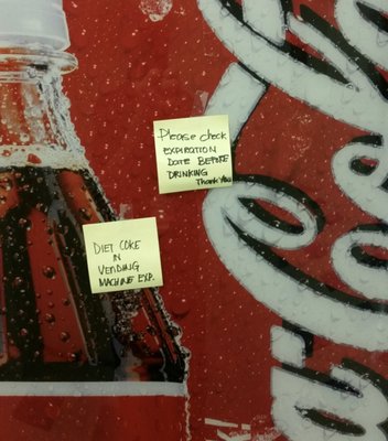 Post-It on the Coke machine reads " Please Check expiration date before drinking"