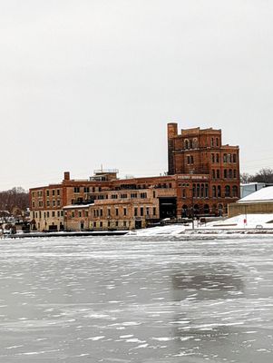 The brewery in the winter from across an icy Rock River