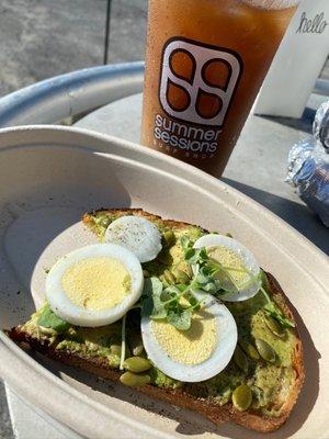 Avocado toast on whole grain bread with micro greens and pepitos. I had them add hard boiled egg slices.