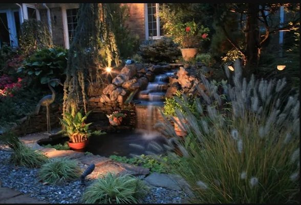 Custom, waterfall and pond with surrounding plantings.