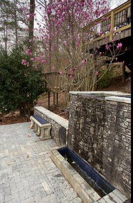 Terrace with retaining wall and water feature.