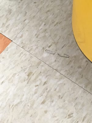 A paper clip bent with the hook end pointing up in an exam room!