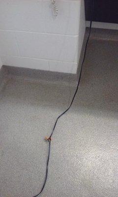 A fan cord had been cut in half and then wire nutted without being wrapped with electrical tape and it is on a wet locker room floor.