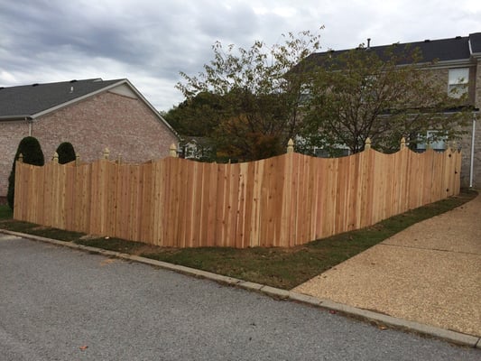 Scalloped cedar fence with French gothic post