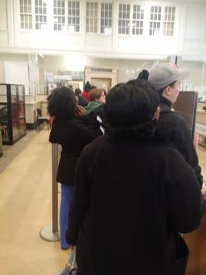 Ppl waiting in line because its only 1 teller and 4 employees doing NOTHING