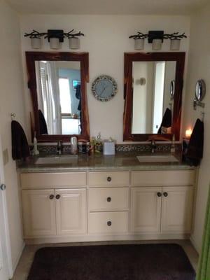 Custom vanity with rectangle under mount sinks, custom granite slab, and glass tile backsplash