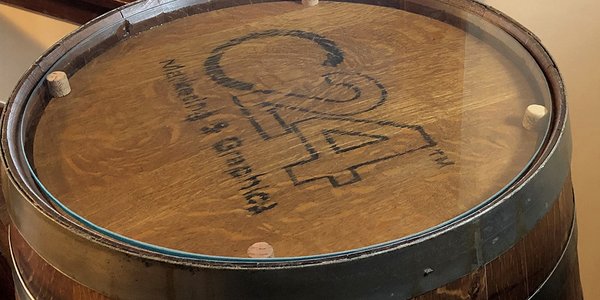 C24 logo branded on a Whiskey Barrel