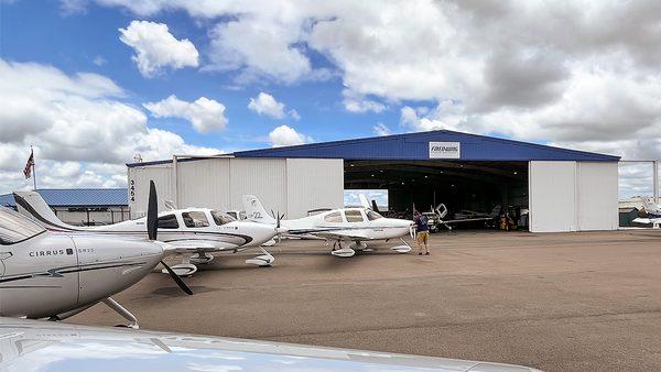 Cirrus airplanes outside hangar.