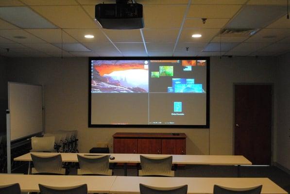 133" Screen in a conference room that is currently displaying 4 different sources at the same time.  Up to 20 total.