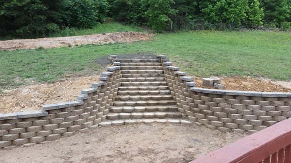 Retaining wall with 15 curving steps running into the main yard.