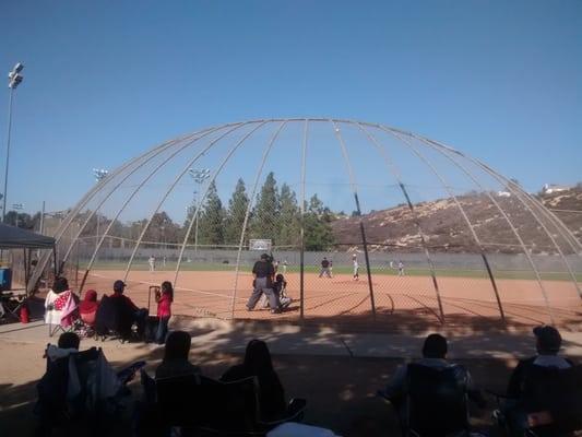 Softball backstops for baseball games doesn't keep the balls from flying out of the field and hitting nearby cars.