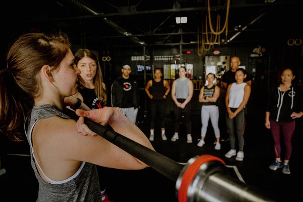 Coach reviewing movement for CrossFit group class