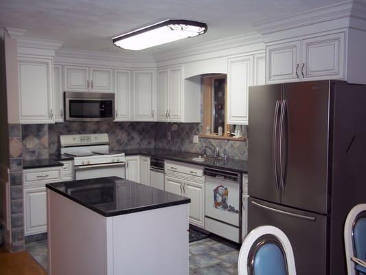 Eye-popping white kitchen with charcoal accent glazing and magnificent crown moulding detail