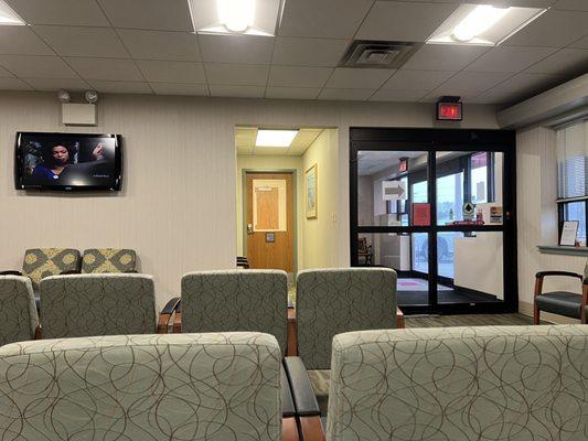 Waiting room area with mounted flat screen TV (partial view)