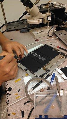 One of our techs cleaning up the corner of a badly damaged iPad metal housing.