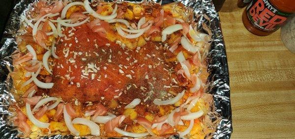 Baked Creole styles salmon with potatoes  peppers and onions