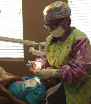 Dr. Rhea E. Radford, pediatric dentist in Pearland, TX.
 Providing extra gentle care to her patient with the parent close by.