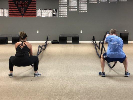 Battle ropes in a full squat position.